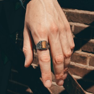 The tiger's eye stone embellished men's silver ring is a stylish accessory that catches the eye.
