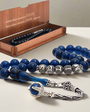 Navy blue squeezing amber rosary and note written in a written box